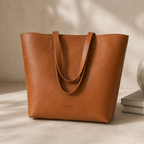 Tan Daygrove tote standing on a tabletop, showing its tapered sides.