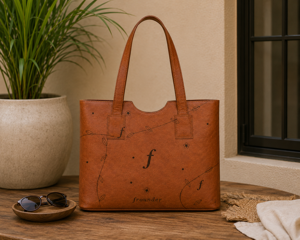 Canopy Work Tote standing on a table beside sunglasses.
