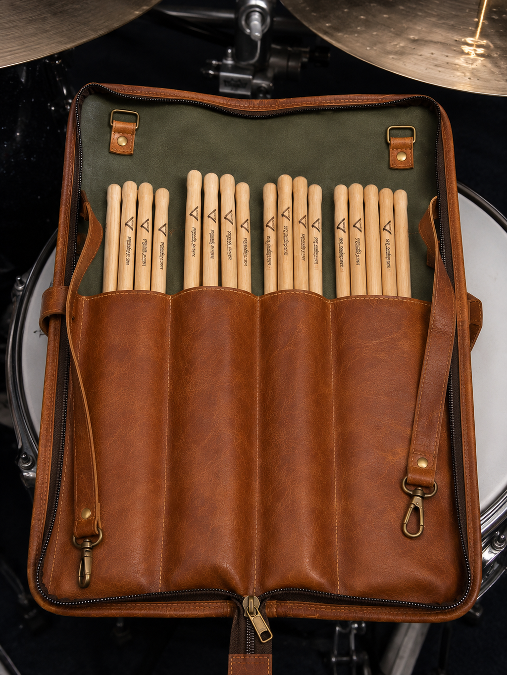 Cadence Stick and Mallet Bag opened beside a drum kit, with drumsticks arranged in the divided interior pockets.
