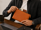Twinleaf and Clay pouch held open with a phone, wallet and pens illustrating the main storage compartment.