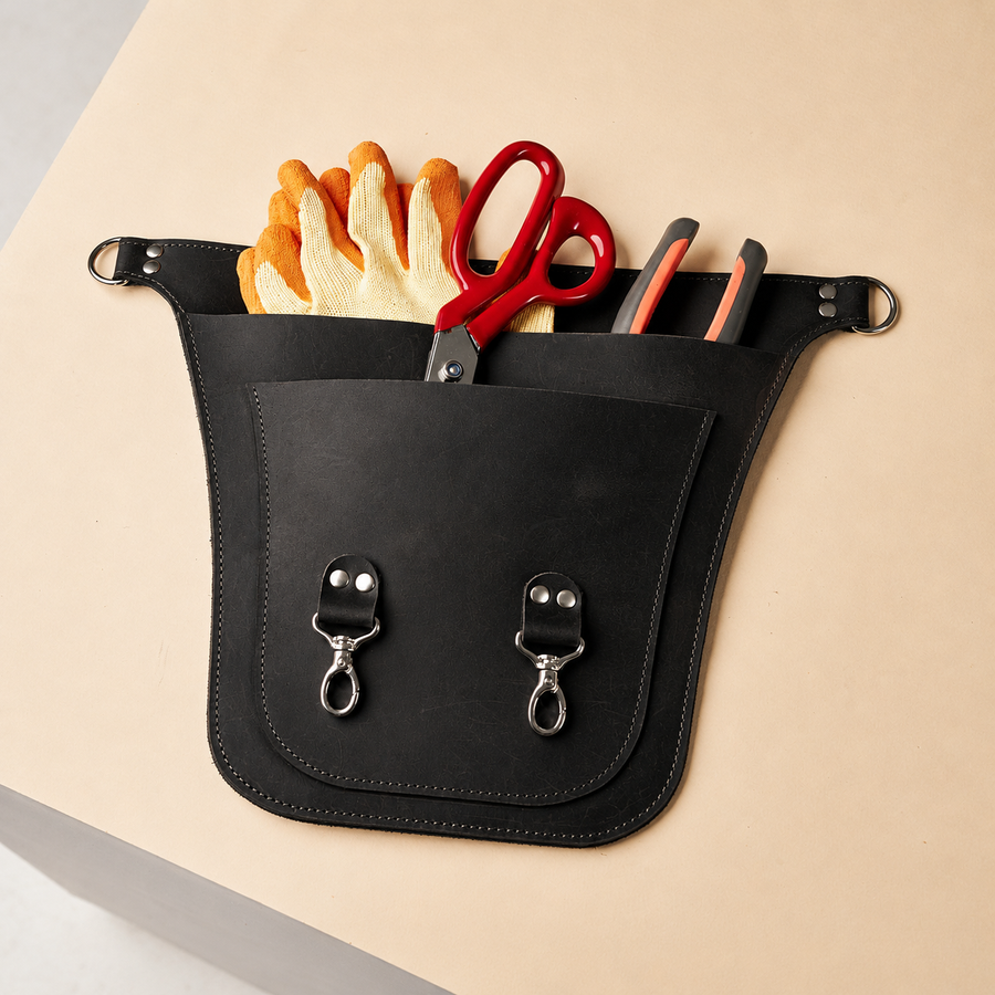 Black Benchside Tool Bag with gloves, scissors and pliers illustrating its layered storage pockets.