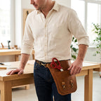 Benchside Tool Bag worn at the hip beside a workbench, with scissors in the front storage area.