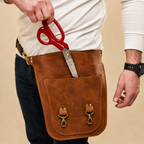 Close view of scissors being lifted from a sleeve in the hip-worn Benchside Tool Bag.