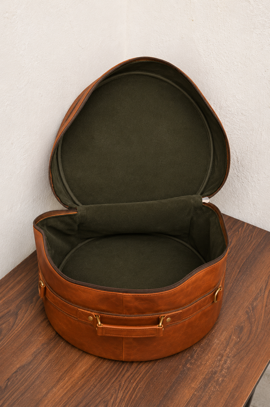Woodnote Drum Bag unzipped, showing the empty lined compartment and circular lid.