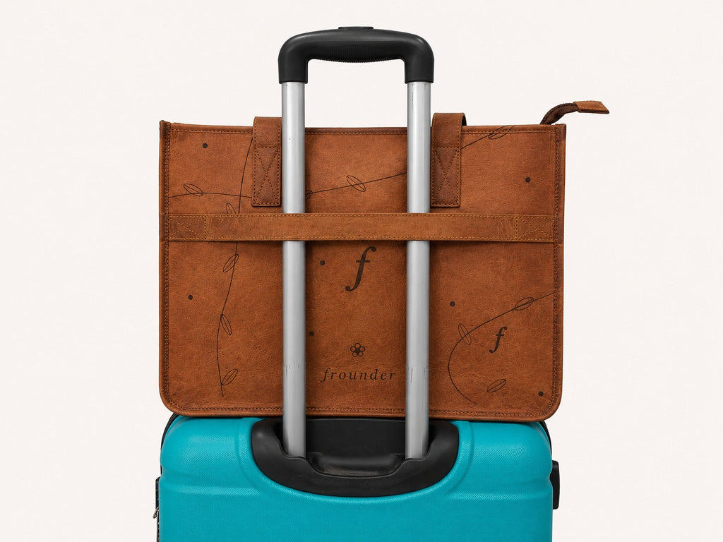 Meadow rear luggage band slipped over the handle of a rolling suitcase.