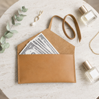 Pocketgrove clutch opened with banknotes illustrating its main pocket.