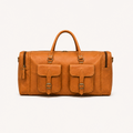 Front view of the tan Cedartrail Travel Duffel, showing two buckled flap pockets, twin rounded handles and zipped compartments at both ends.