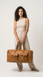 Tan Cedartrail Travel Duffel held in front of the body with both hands on the top handles.