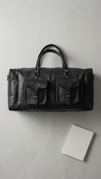 Black Cedartrail Travel Duffel arranged on a pale surface beside a journal, with its front pockets and top handles visible.